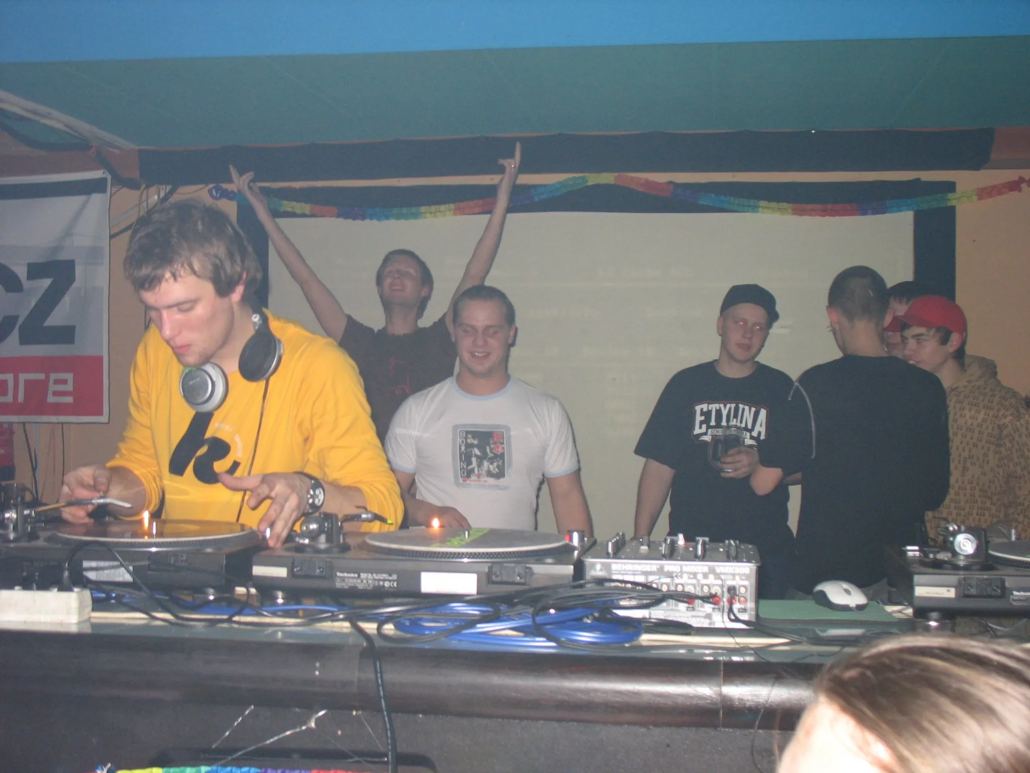 A young DJ Kita mixing on vinyl turntables in a packed club